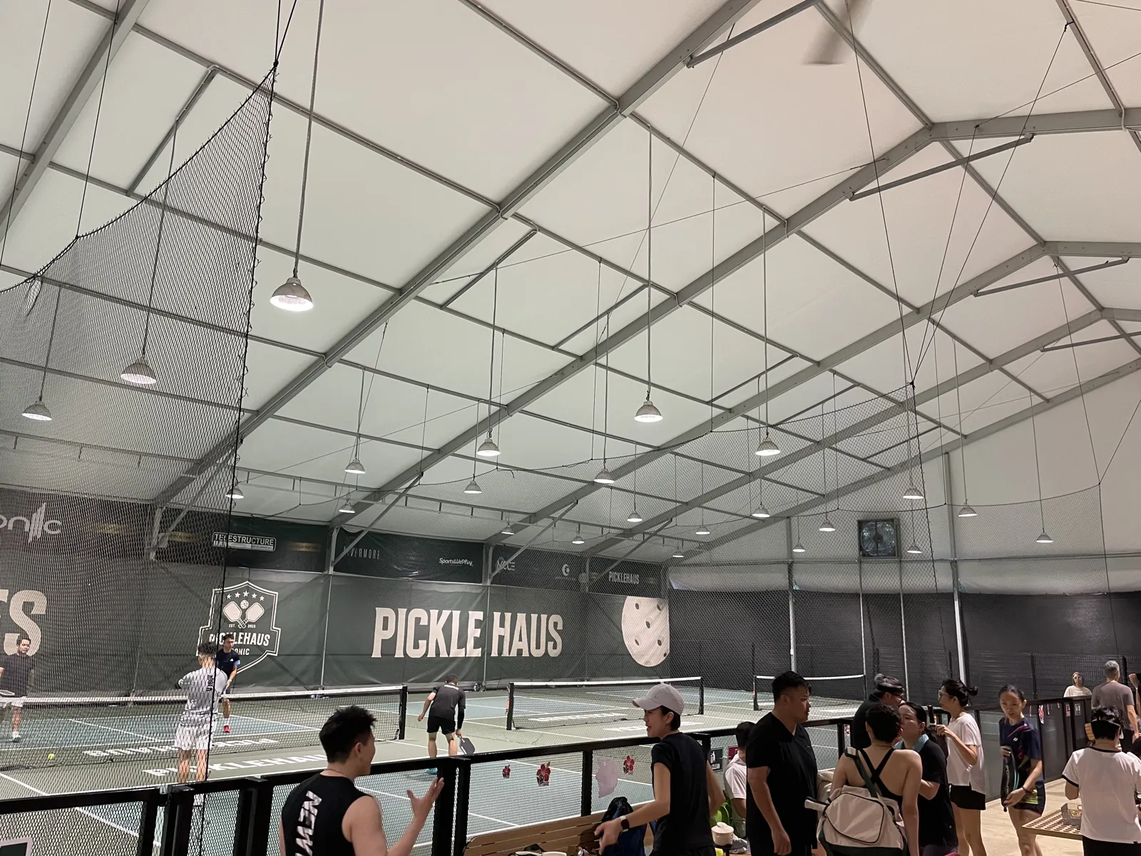 Players waiting courtside at PickleHaus by Iconic in George Town